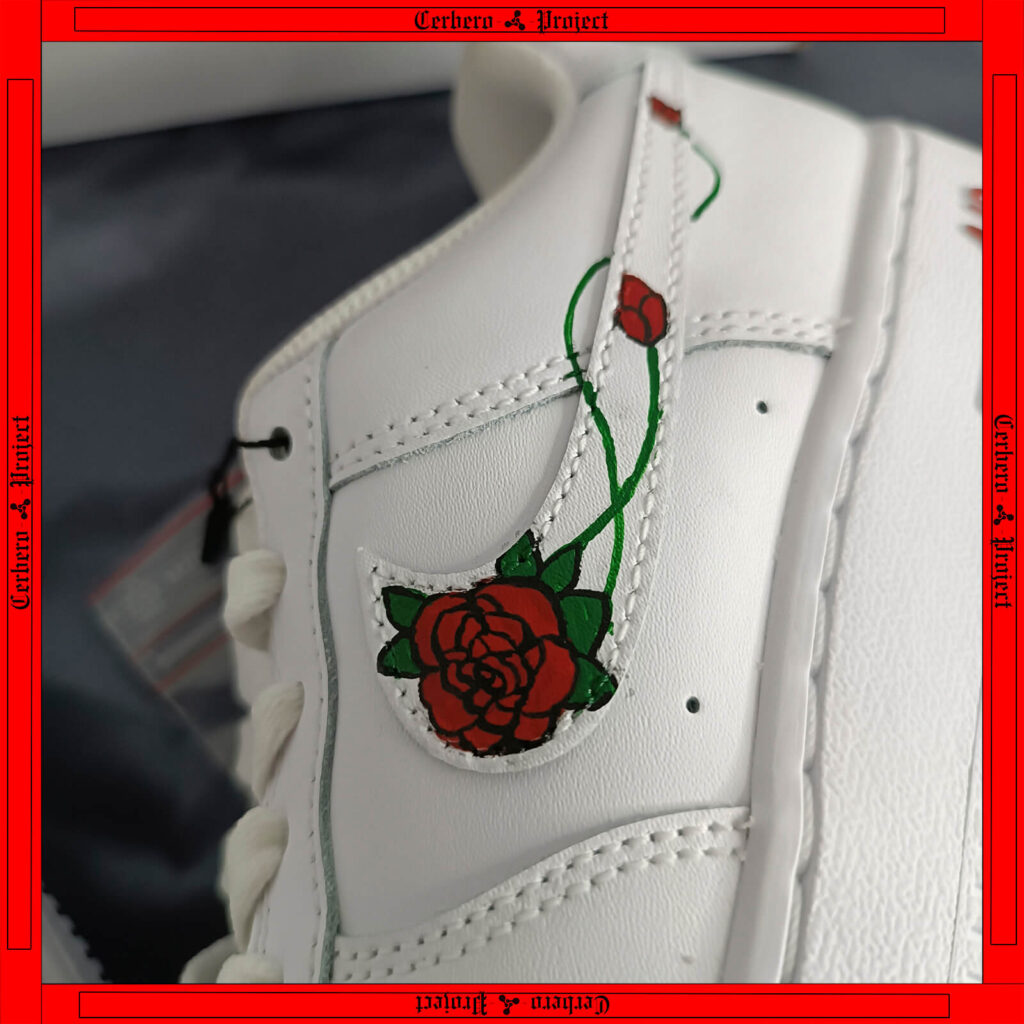 Close-up of white sneaker with a rose-embroidered swoosh detail from the Cerbero Project
