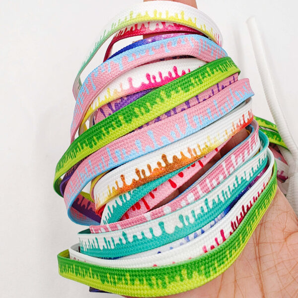Hand holding a bundle of multicolor ice cream laces with drip design