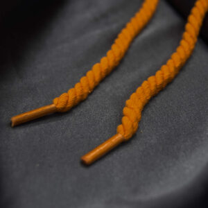 Orange rope laces displayed on gray satin